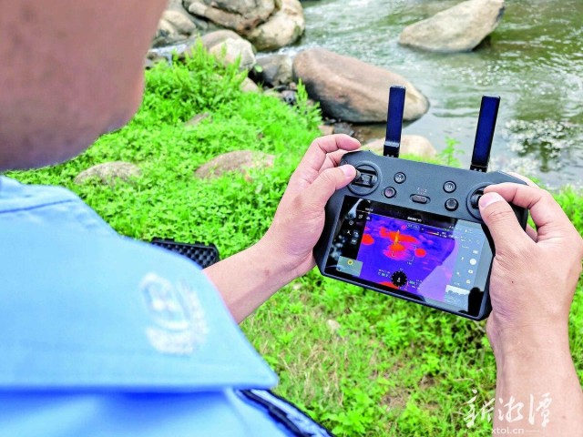 600-xxt2025-05-21～1｜在网红打卡点白龙滩，民警林国迅操作无人机巡视和喊话群众注意安全。（本报记者 刘建强 摄）a42c.jpg